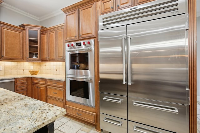 kitchen featuring stainless steel appliances, ornamental molding, brown cabinets, and decorative backsplash