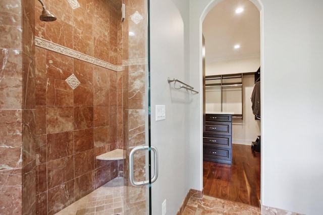 bathroom featuring a stall shower, ornamental molding, a walk in closet, and recessed lighting