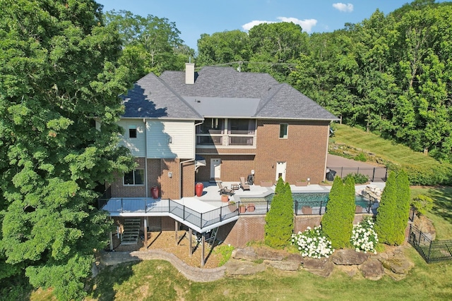 back of property featuring a chimney, stairs, fence, and brick siding