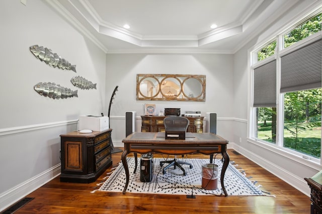 office space featuring hardwood / wood-style flooring, visible vents, a tray ceiling, and ornamental molding