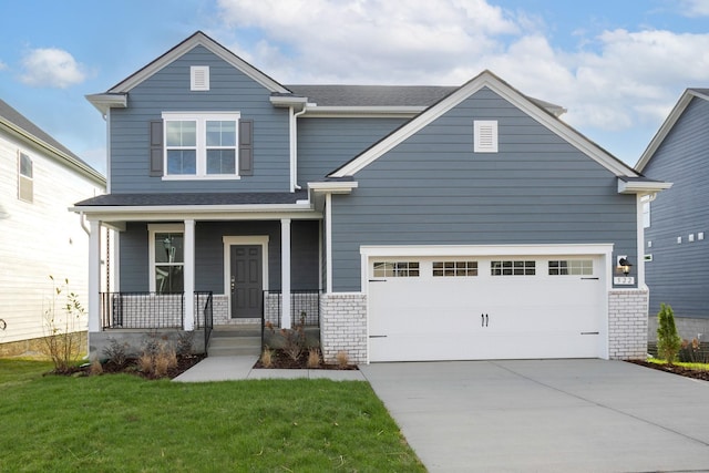 view of front facade with a porch, brick siding, a shingled roof, driveway, and a front yard