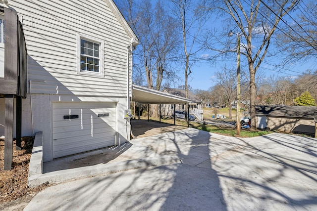 view of side of property featuring a carport and concrete driveway