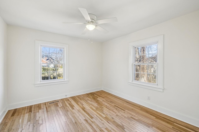 unfurnished room with light wood-style floors, visible vents, ceiling fan, and baseboards