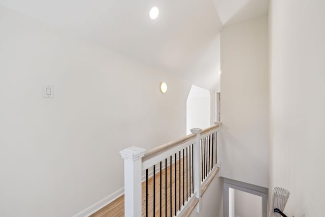 hall featuring recessed lighting, baseboards, wood finished floors, and an upstairs landing