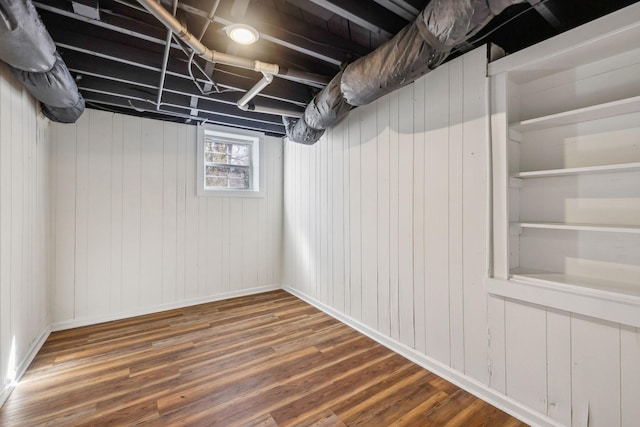 basement featuring baseboards and wood finished floors