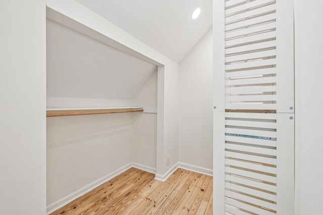 spacious closet with vaulted ceiling and hardwood / wood-style floors