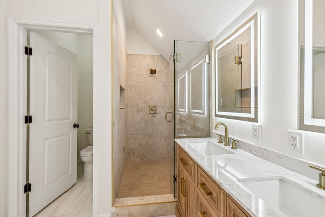 bathroom with a sink, a shower stall, toilet, and double vanity