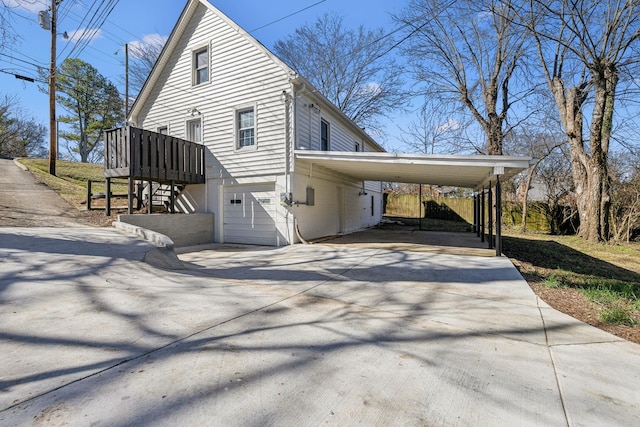 view of property exterior featuring driveway, an attached garage, and a carport