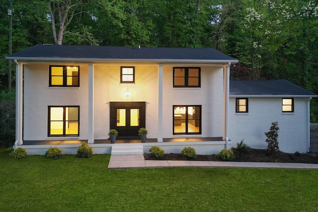 view of front of home with brick siding and a front lawn