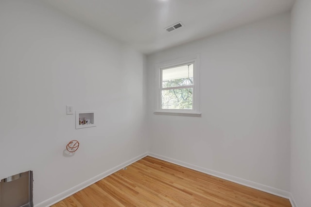 clothes washing area featuring hookup for a washing machine, visible vents, light wood-type flooring, laundry area, and baseboards
