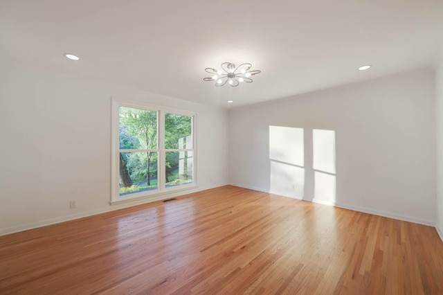 unfurnished room with recessed lighting, visible vents, an inviting chandelier, light wood-type flooring, and baseboards