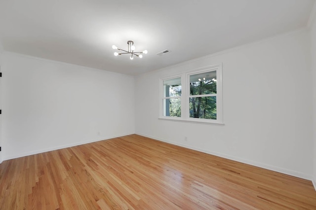 empty room with visible vents, baseboards, light wood-type flooring, an inviting chandelier, and crown molding