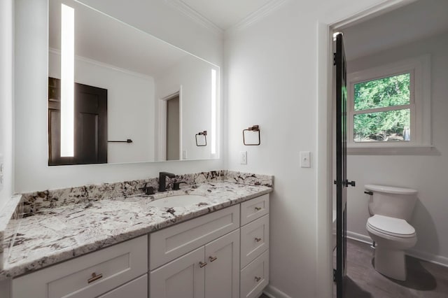 bathroom with toilet, baseboards, ornamental molding, and vanity