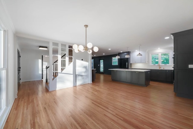kitchen featuring light wood-type flooring, light countertops, a sink, and a center island