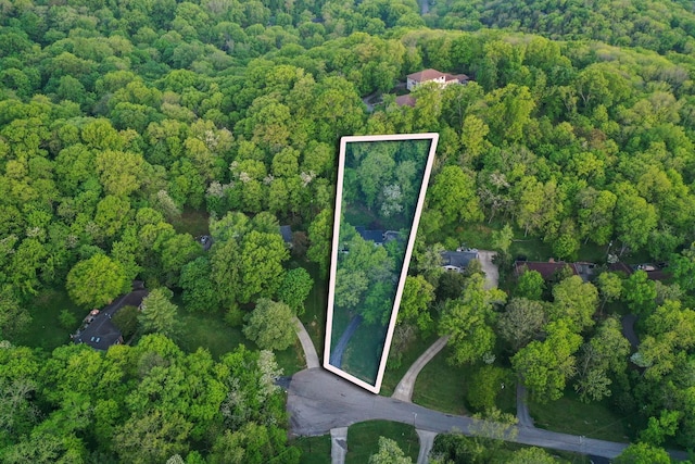 birds eye view of property featuring a wooded view