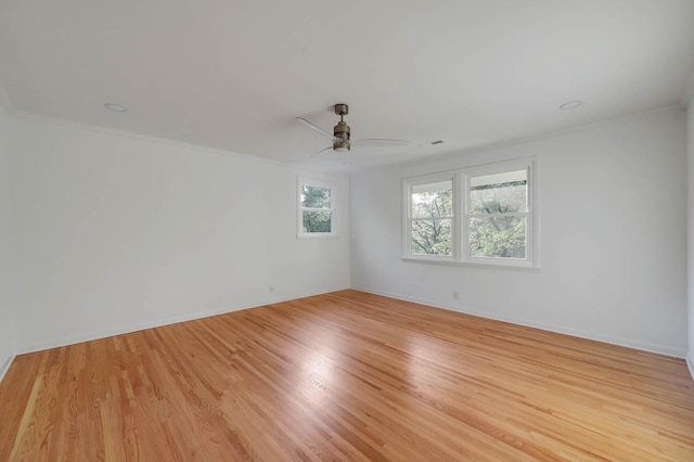 unfurnished room with light wood finished floors, ceiling fan, baseboards, and crown molding