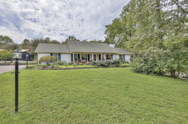 single story home with a front yard, covered porch, and driveway