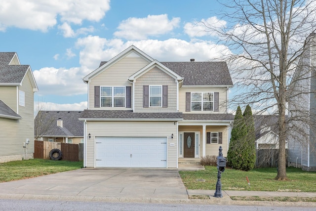 traditional-style house featuring a front lawn, concrete driveway, fence, and a garage