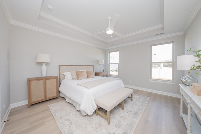 bedroom with light wood-style flooring, visible vents, baseboards, and ornamental molding