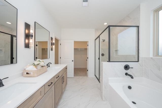 bathroom featuring marble finish floor, a shower stall, and a sink