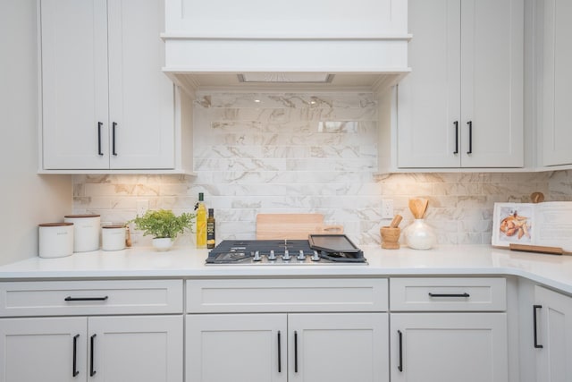 kitchen featuring stainless steel gas stovetop, custom exhaust hood, and light countertops