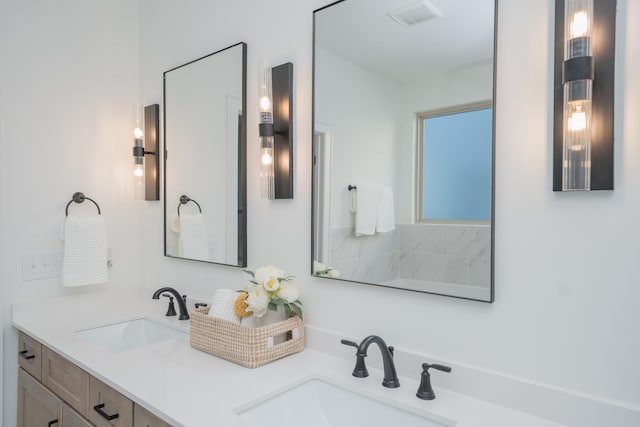 bathroom featuring double vanity, a sink, and visible vents