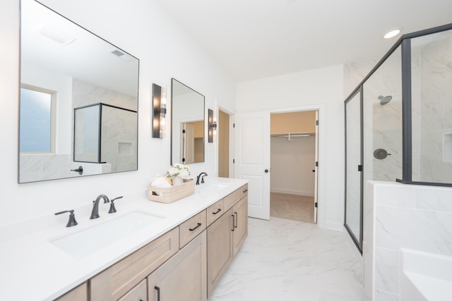 bathroom featuring marble finish floor, a sink, a marble finish shower, and a walk in closet