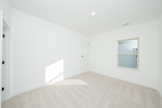 carpeted spare room featuring visible vents and baseboards