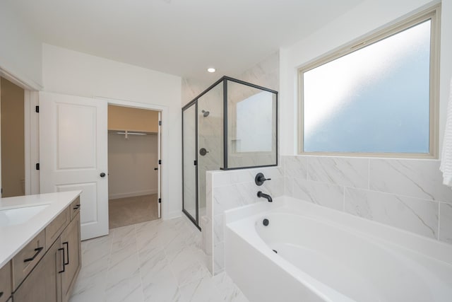 bathroom with a garden tub, vanity, marble finish floor, a stall shower, and a walk in closet