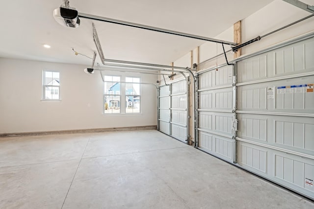 garage featuring a garage door opener and baseboards