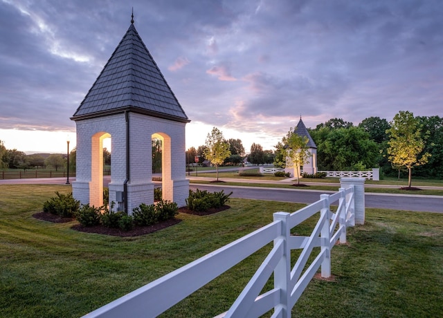 view of home's community with fence and a yard