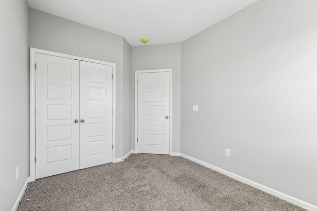 unfurnished bedroom featuring a closet, carpet flooring, and baseboards