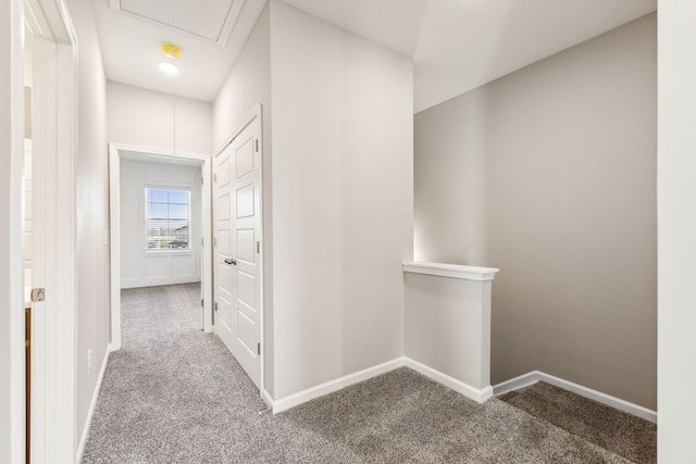 hallway featuring an upstairs landing, carpet flooring, attic access, and baseboards