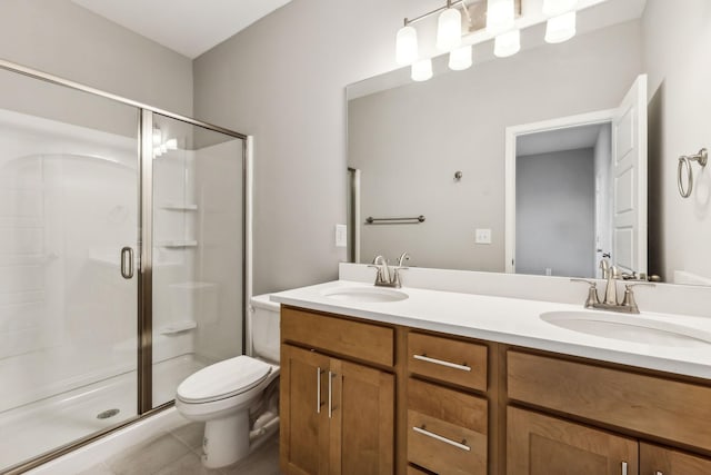 full bath featuring a stall shower, a sink, and toilet