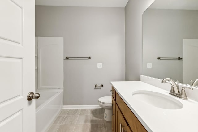 bathroom featuring toilet, a bathing tub, vanity, baseboards, and tile patterned floors