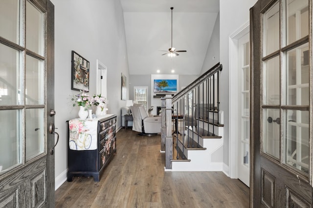 entrance foyer featuring baseboards, a ceiling fan, hardwood / wood-style flooring, stairs, and high vaulted ceiling