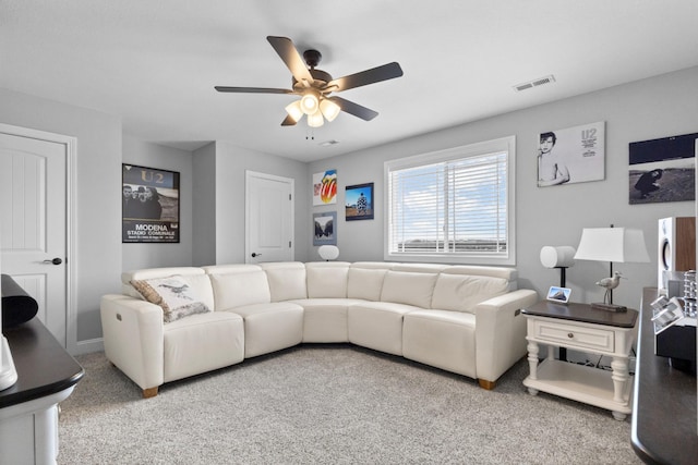 living room featuring carpet, visible vents, and a ceiling fan