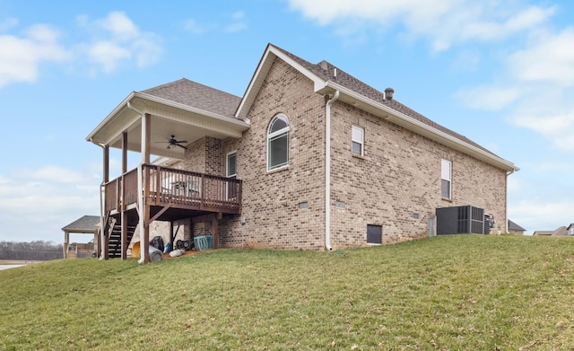 back of house featuring cooling unit, stairway, a lawn, and brick siding