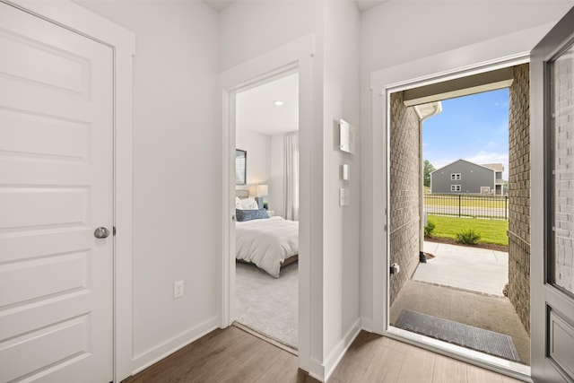 doorway featuring baseboards and wood finished floors