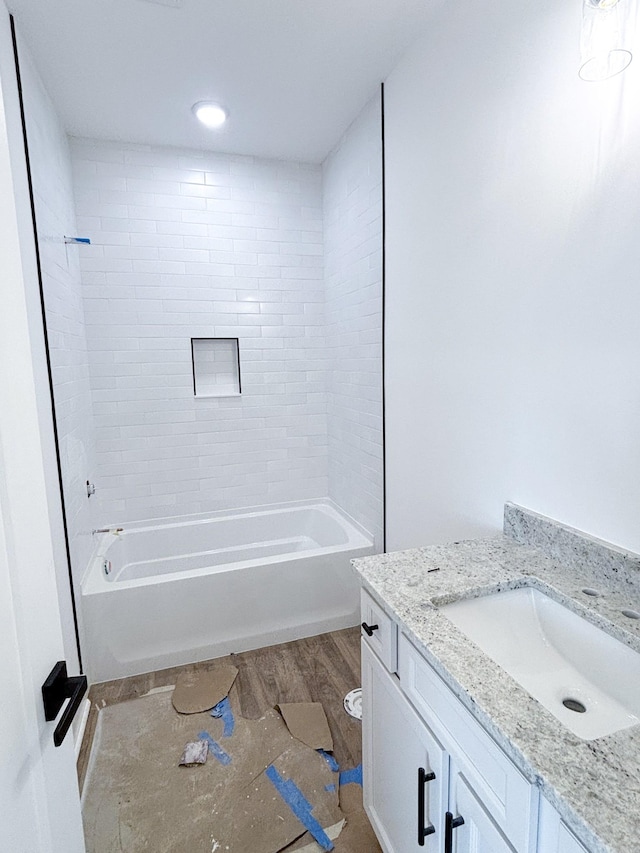 full bathroom with wood finished floors, vanity, and shower / bathtub combination