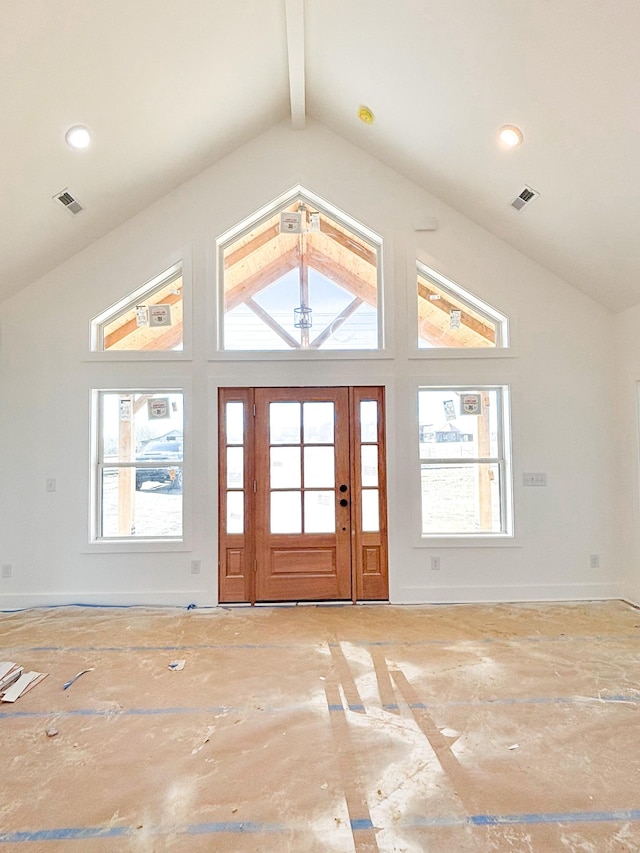 entrance foyer featuring visible vents, plenty of natural light, beamed ceiling, and baseboards