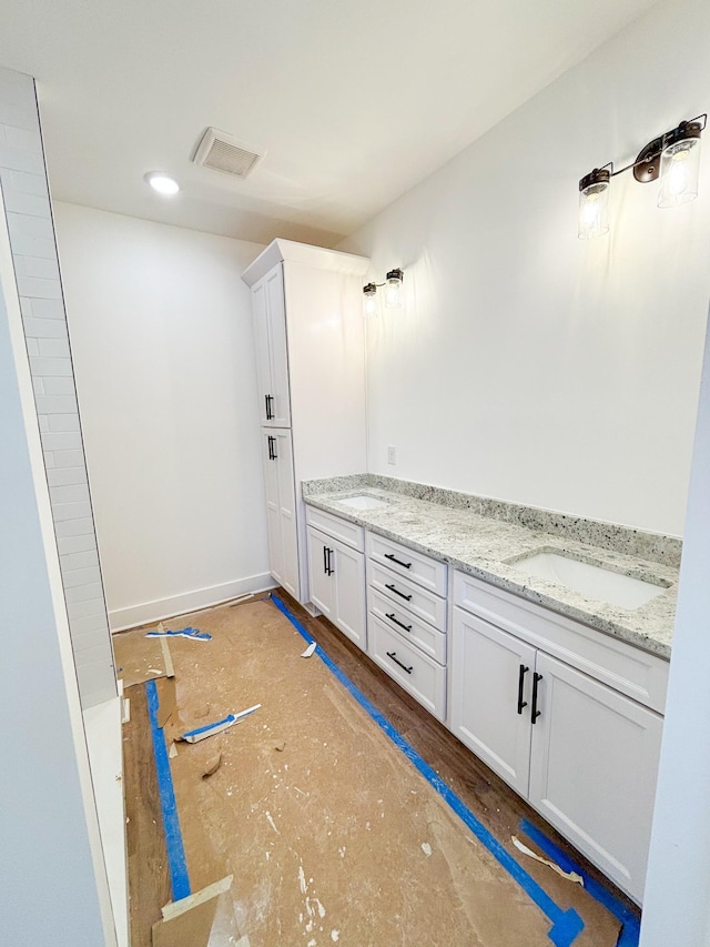 bathroom featuring visible vents, a sink, and double vanity