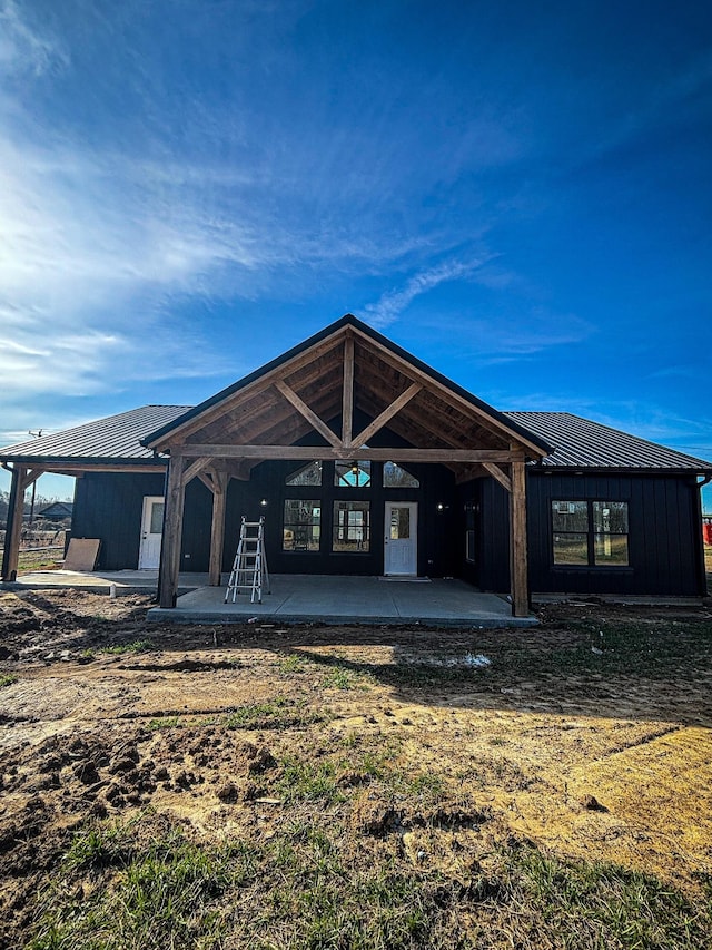 rear view of property with a standing seam roof, metal roof, and a patio