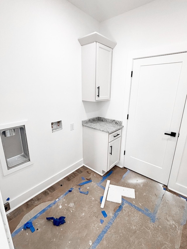 clothes washing area featuring hookup for a washing machine, cabinet space, and baseboards