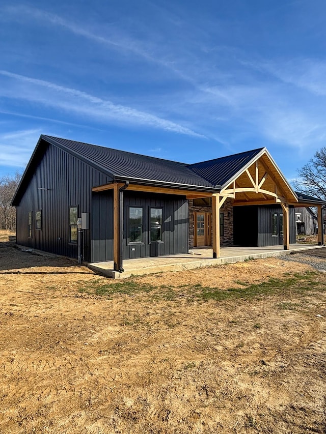 rear view of house with metal roof and board and batten siding