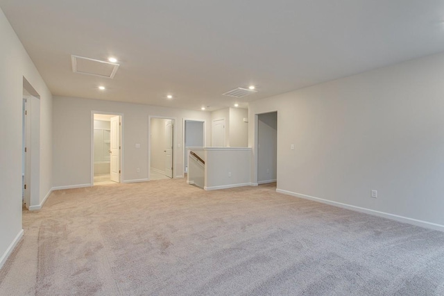 empty room with attic access, recessed lighting, light carpet, and baseboards