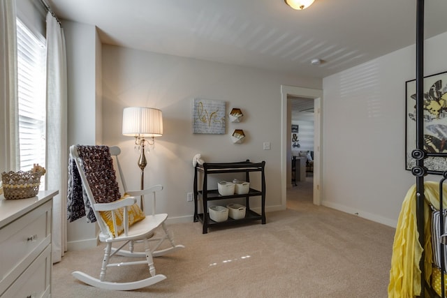 sitting room with light carpet, baseboards, and a wealth of natural light