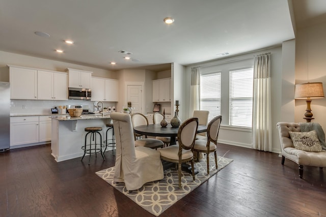 dining space with dark wood-style flooring, recessed lighting, visible vents, and baseboards