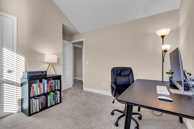 carpeted home office featuring vaulted ceiling and baseboards