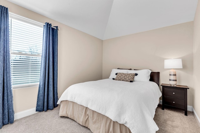 carpeted bedroom with vaulted ceiling and baseboards